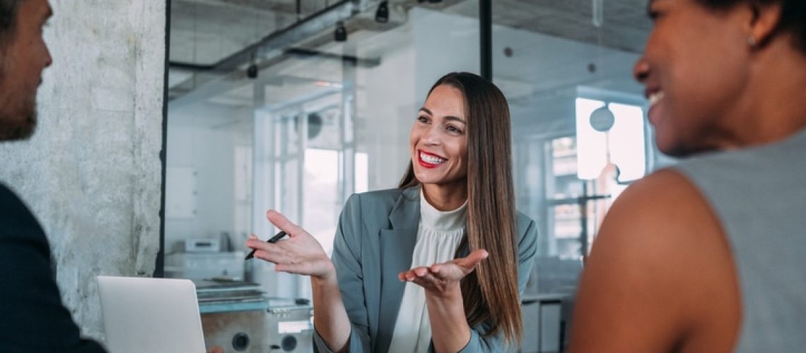 Shot of group of business persons in business meeting. Three entrepreneurs on meeting in board room. Corporate business team on meeting in modern office. Female manager discussing new project with her colleagues. Company owner on a meeting with two of her employees in her office.